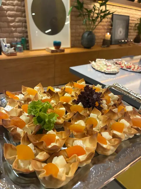 Cestinhas crocantes recheadas com queijo e damasco, decoradas com folhas de alface