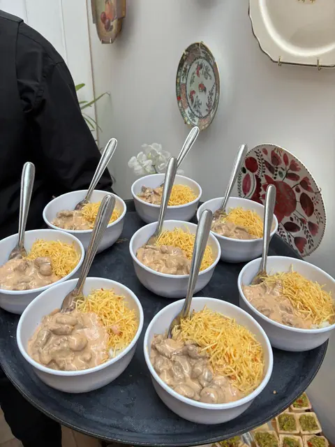 Cumbuquinhas brancas com estrogonofe e batata palha, servidas em bandeja com colheres